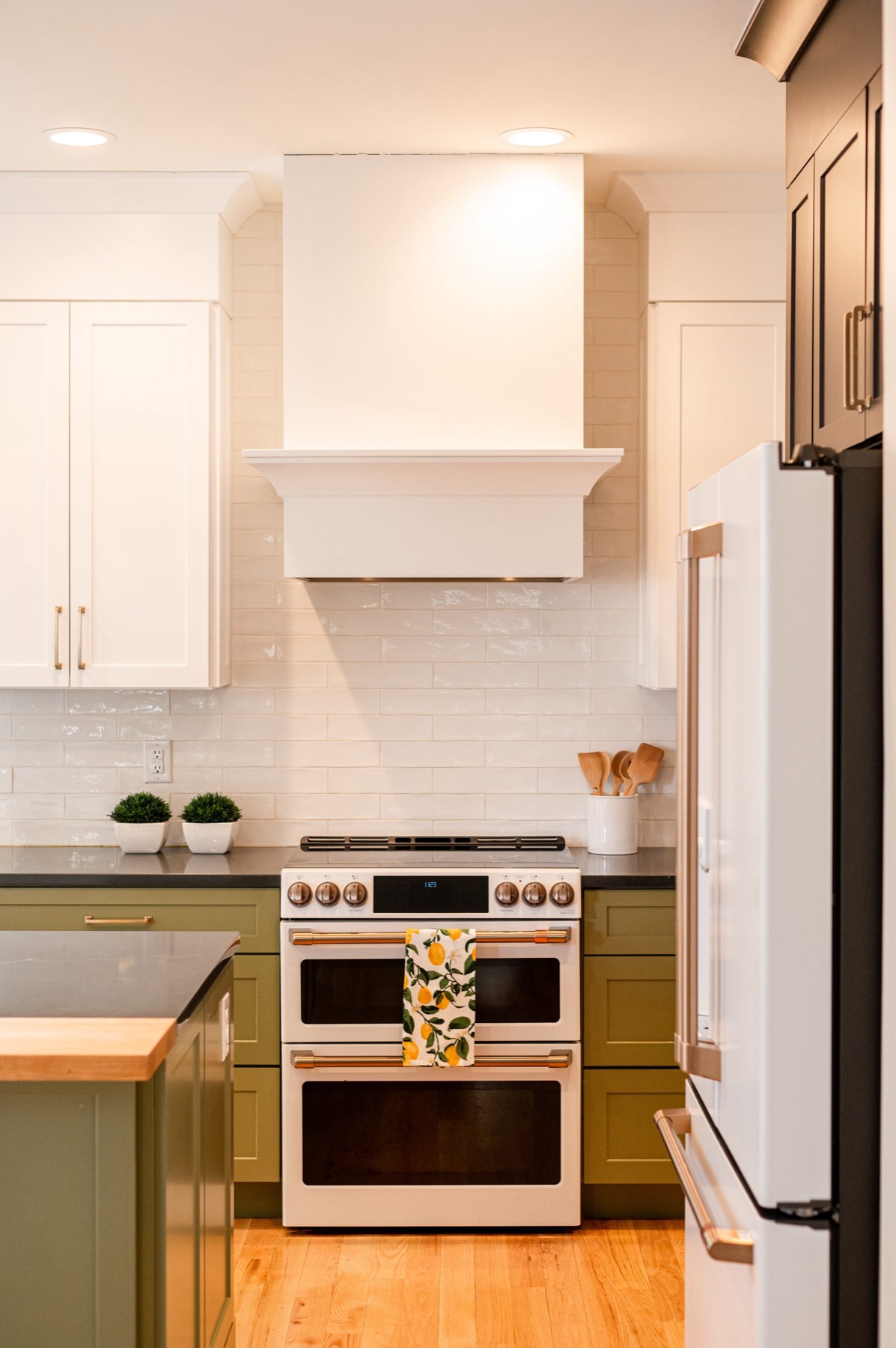 Remodeled kitchen with olive green cabinetry and white range