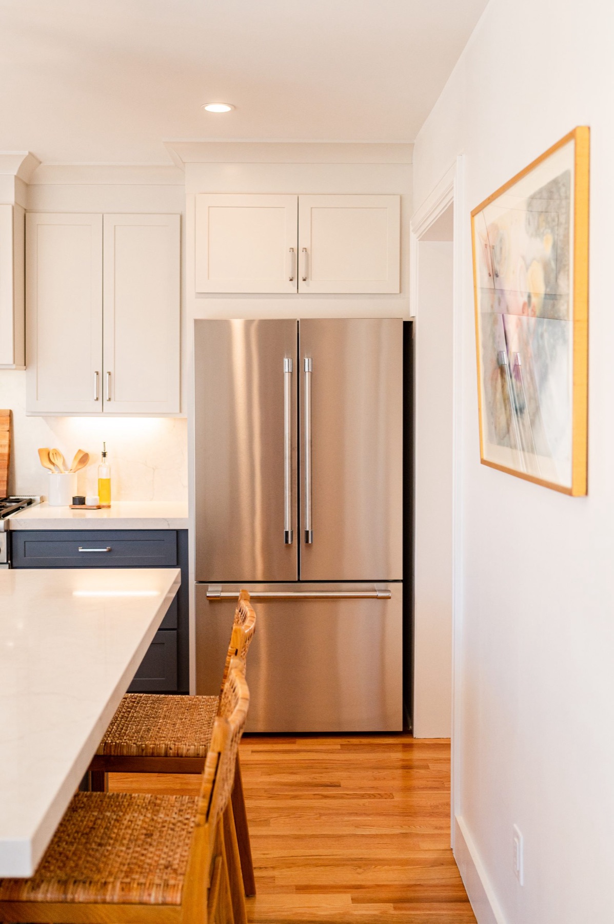 Bright remodeled kitchen with white cabinetry and wood accents