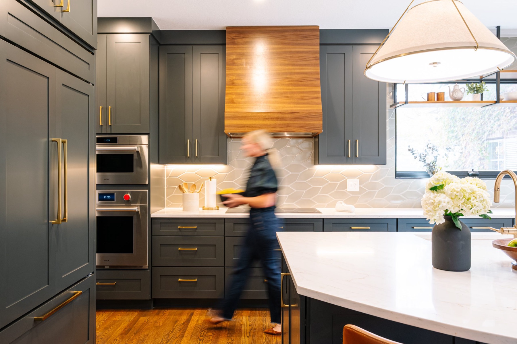 Kitchen remodel in progress with dark cabinetry and wood hood